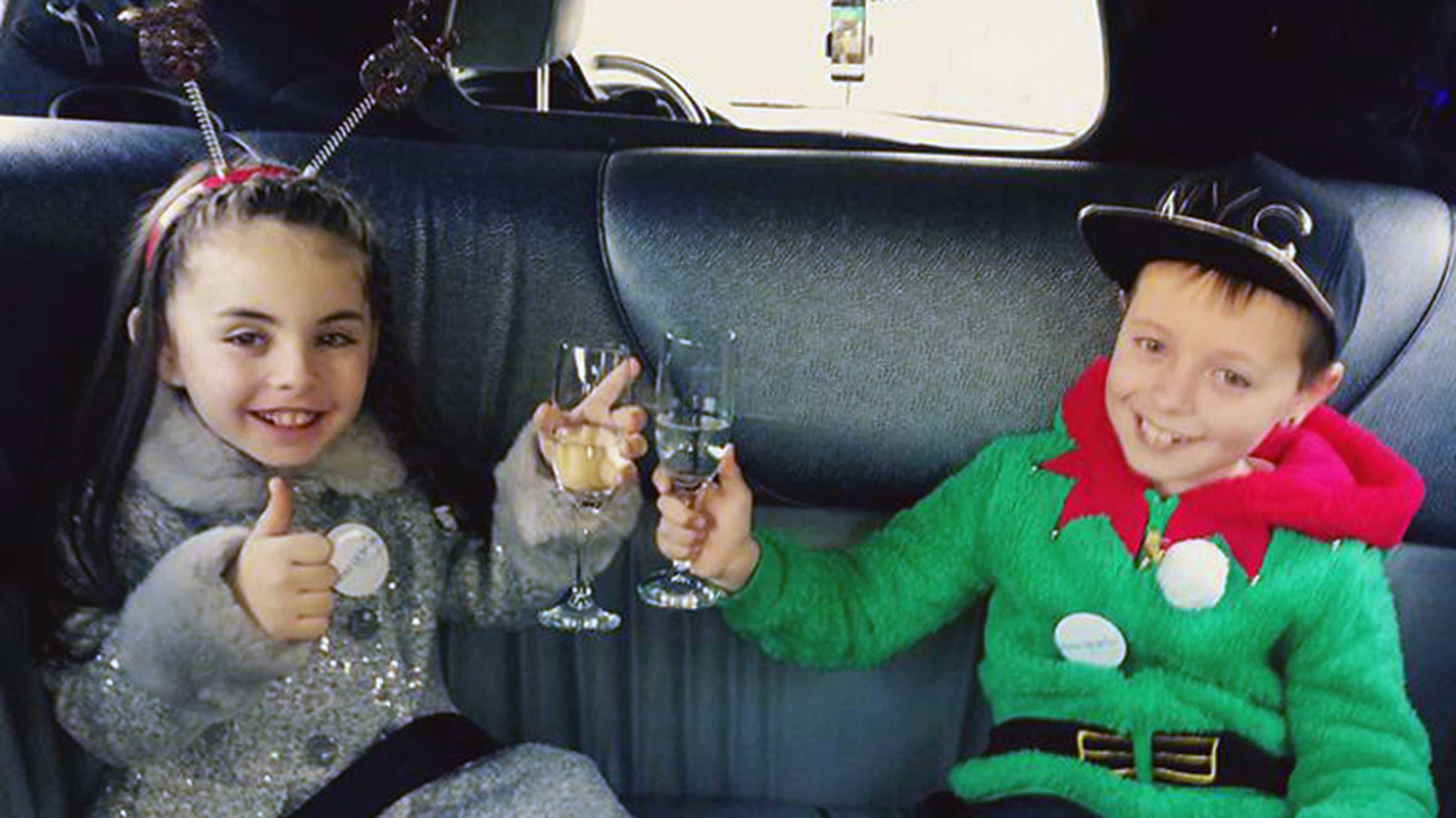 Ella and her brother cheersing lemonade in a limo