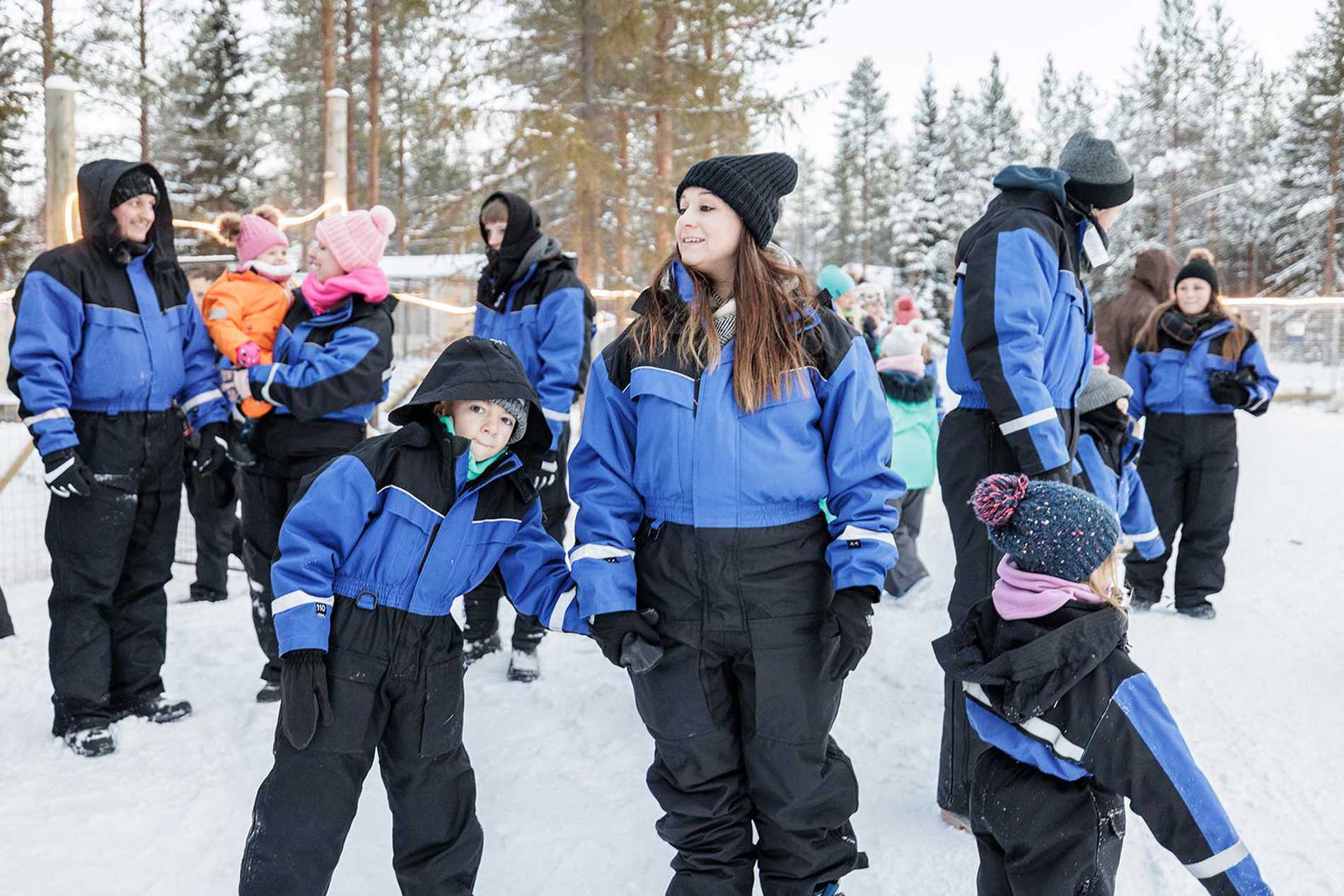 A group photo of the family in their blue snowsuits.