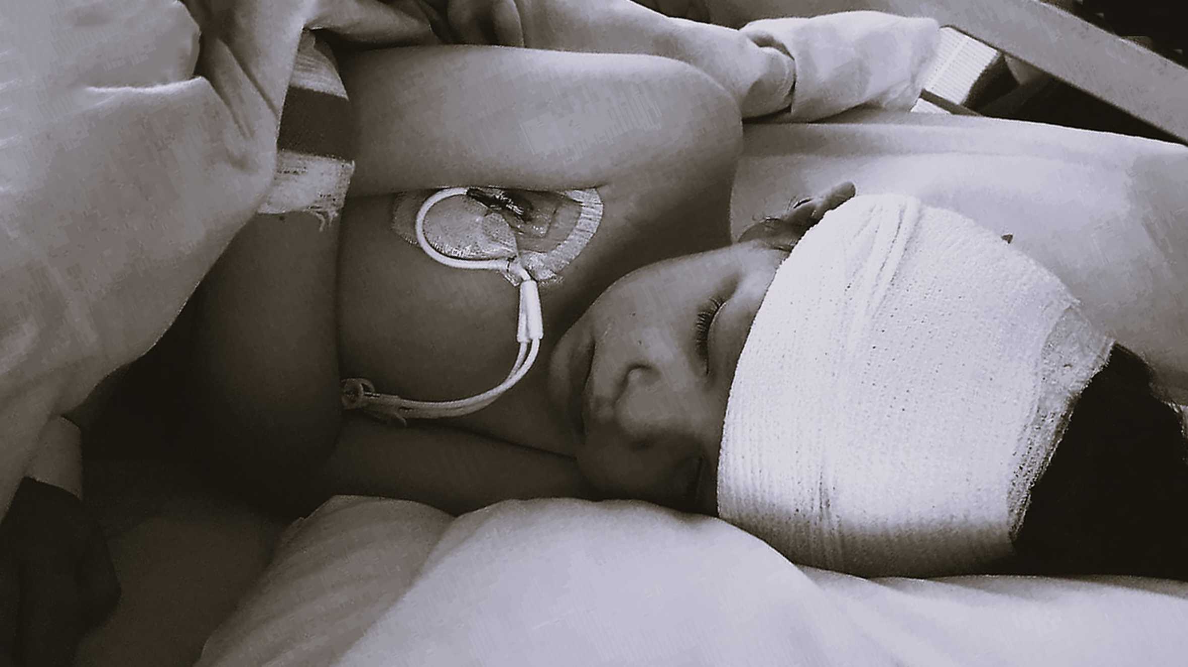 A black and white image of wish child, Aaron lying in his hospital bed, undergoing treatment for his condition.