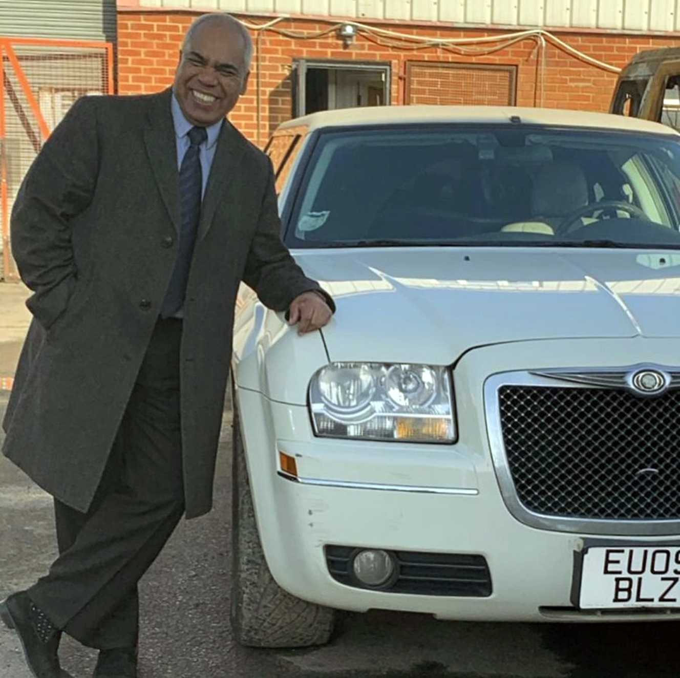 Wish Hero, Edmund standing in front of one of the limos he drives