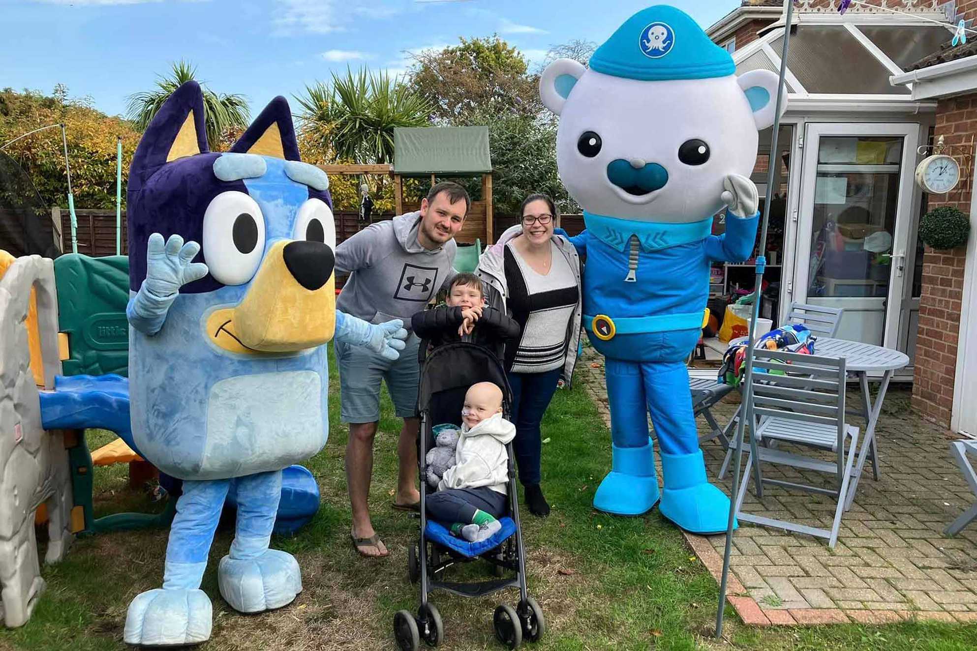 Finley and his family in their garden with two of the Paw Patrol characters.
