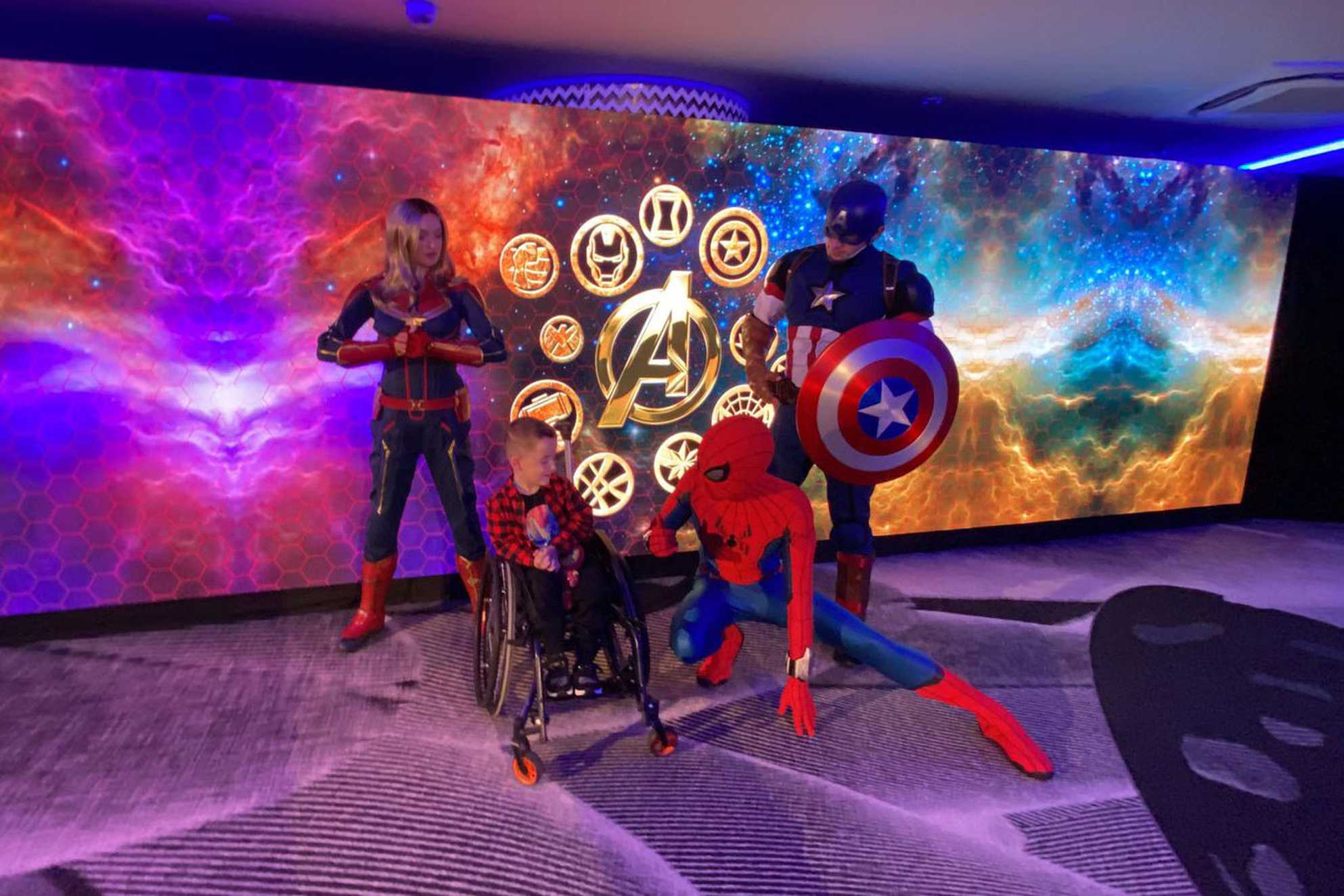 Lincoln posing for a photograph with some Marvel characters.