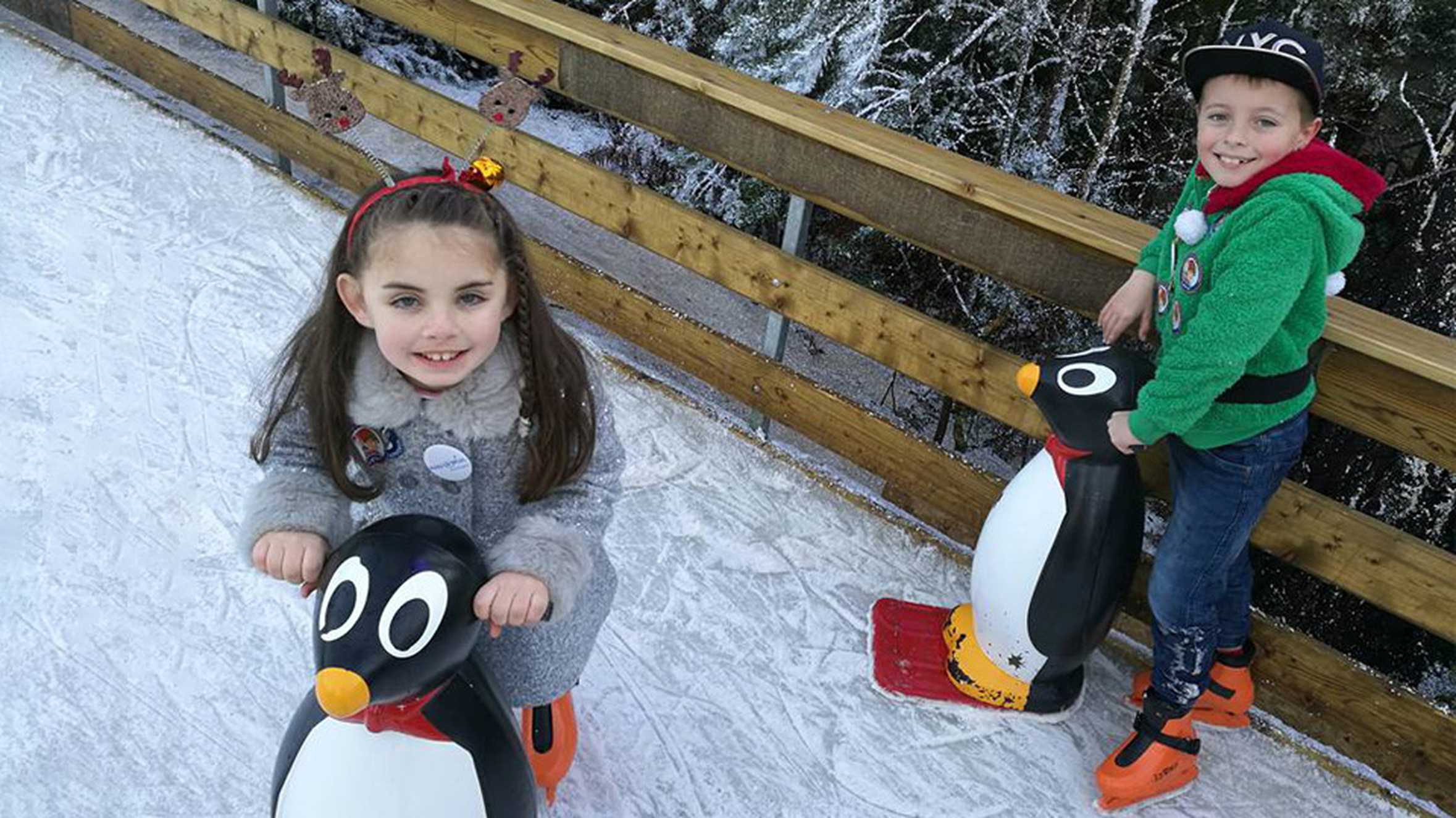 Ella and her brother both smiling while ice skating