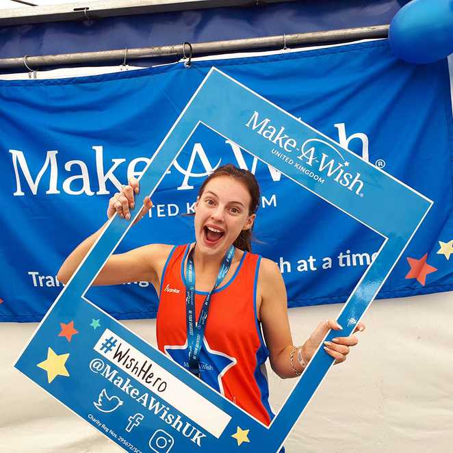 A #Wishhero taking a selfie inside a Make-A-Wish frame after completing the London Landmarks Half Marathon.