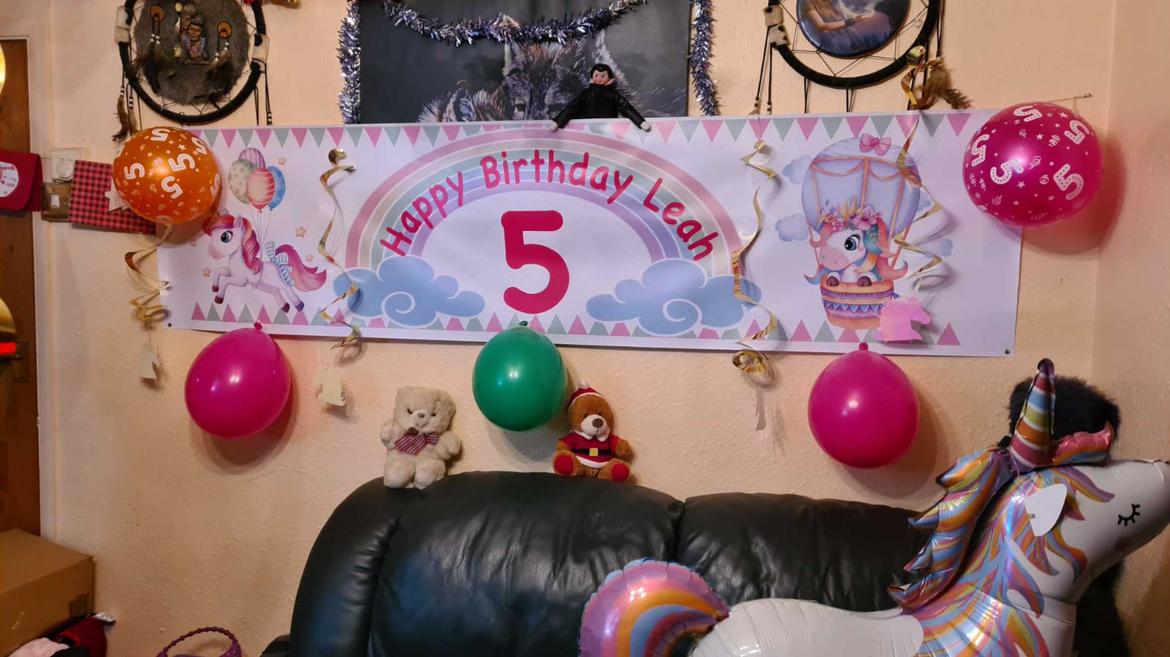 Leah's birthday decorations, including a large 'happy birthday' banner and unicorn balloon.