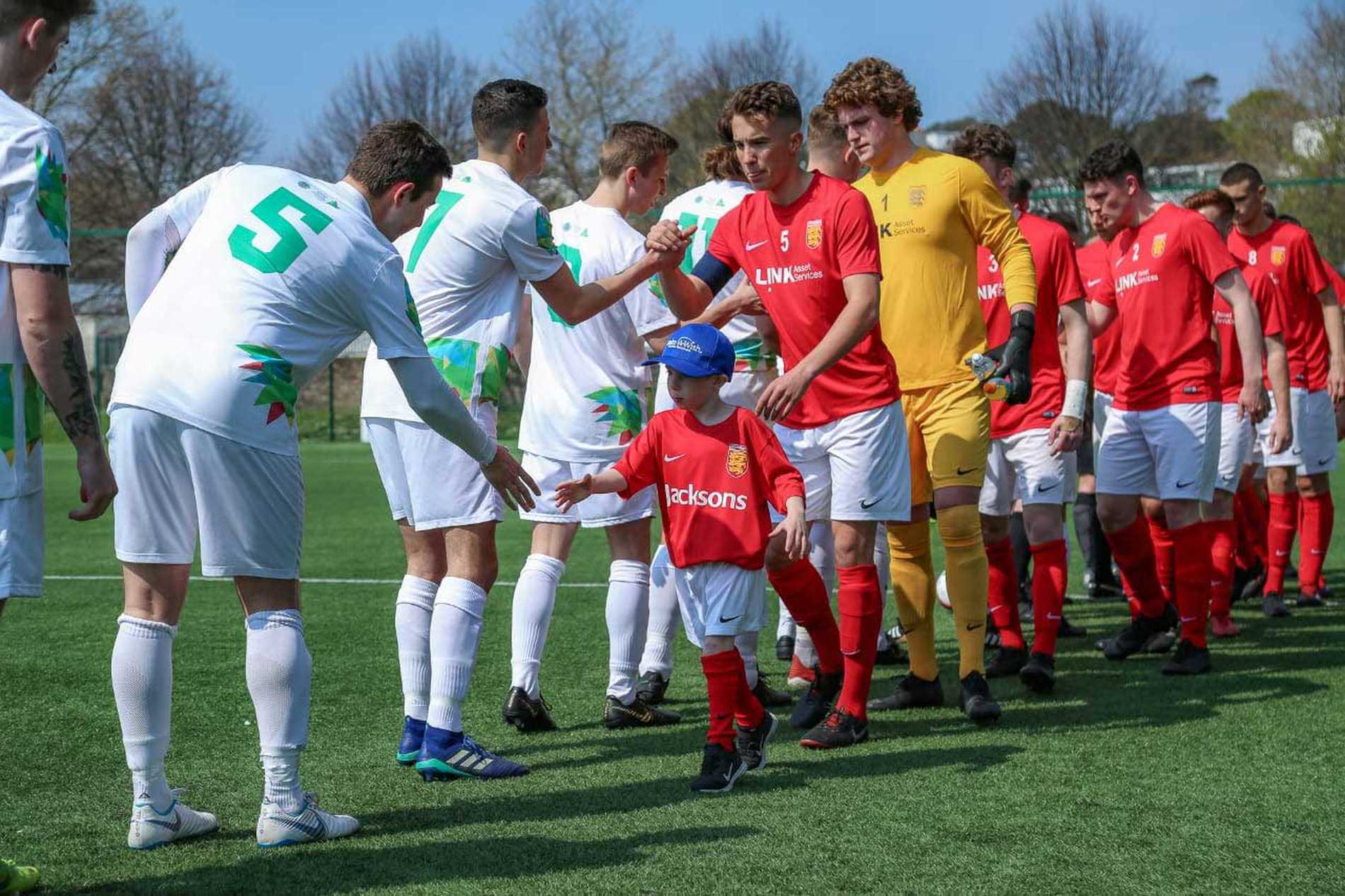 Wish child Jayden shaking hands with the players of the opposition during his wish