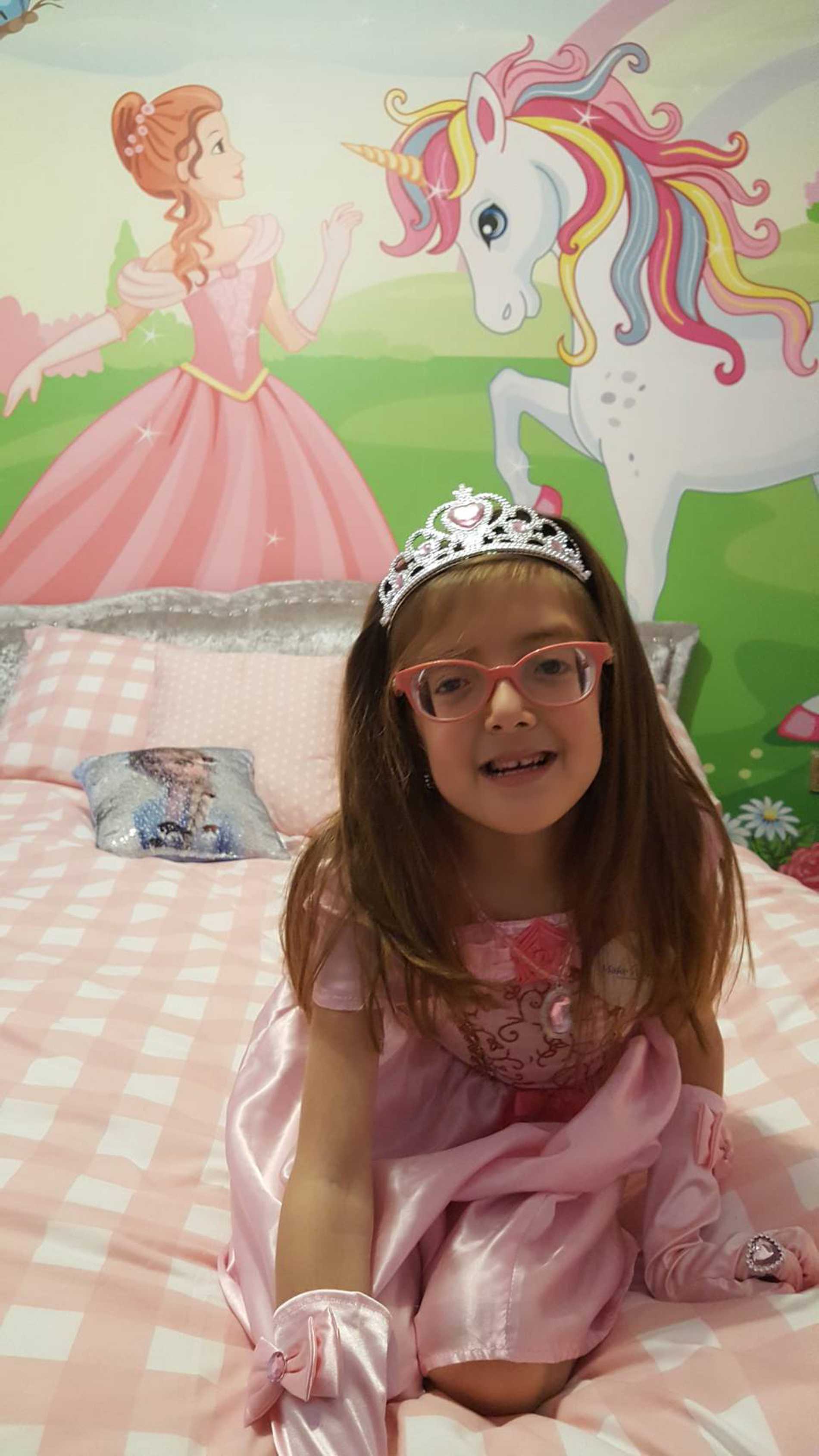 Smiling wish child, Tiara in her princess-themed bedroom.